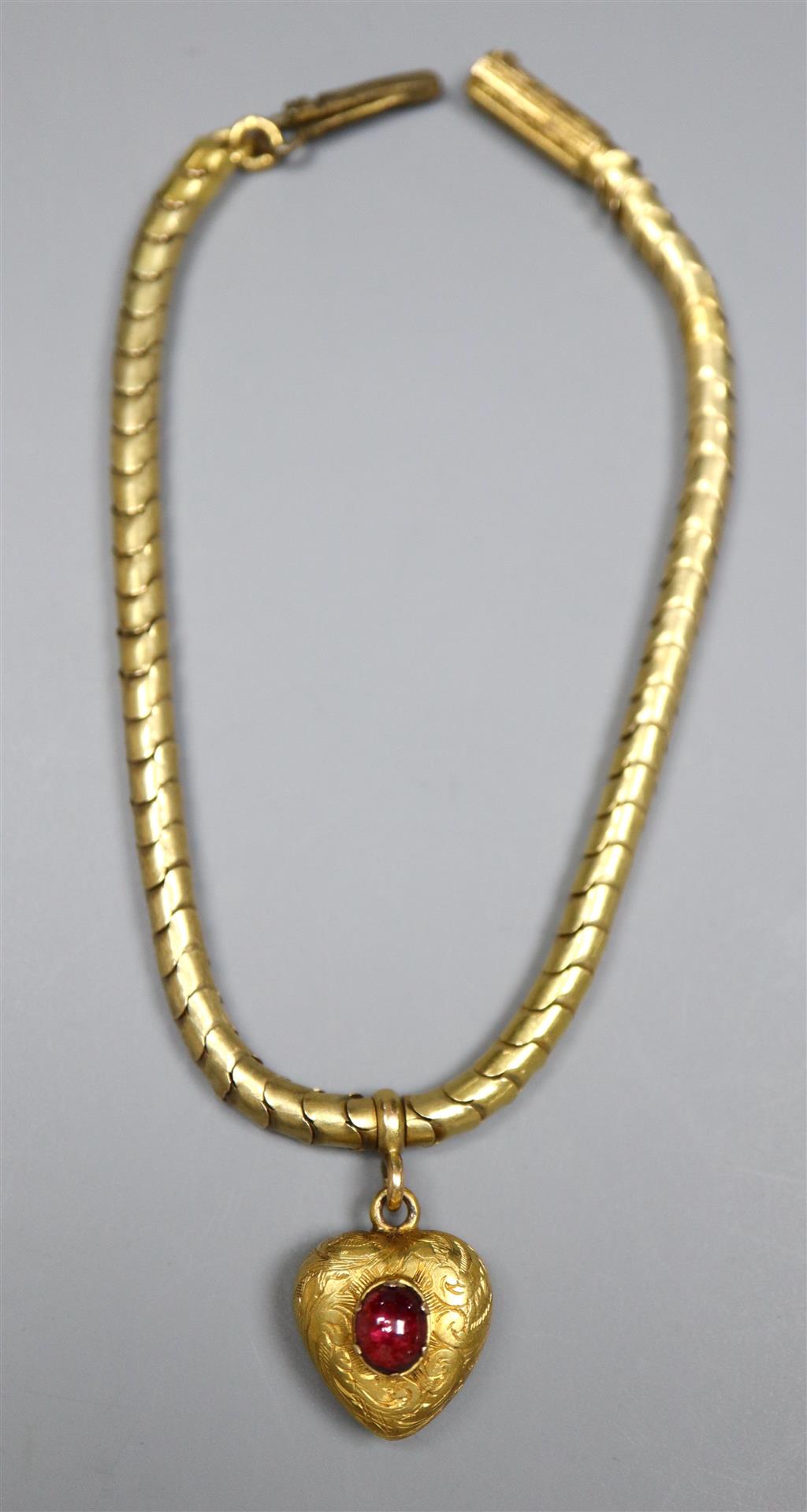 A Victorian yellow metal snakelink mourning bracelet, hung with a garnet set heart shaped charm with glazed back,